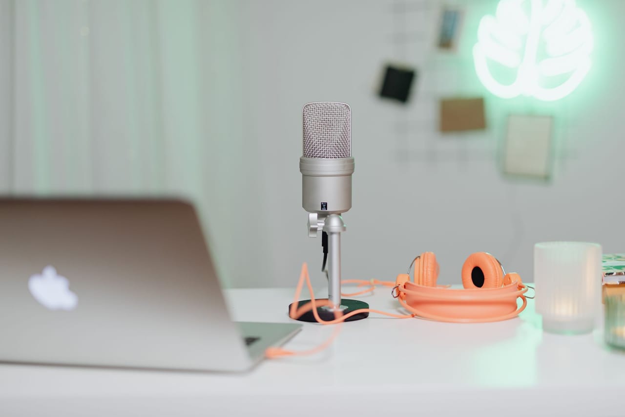 Microphone and headphones on a desk next to a laptop